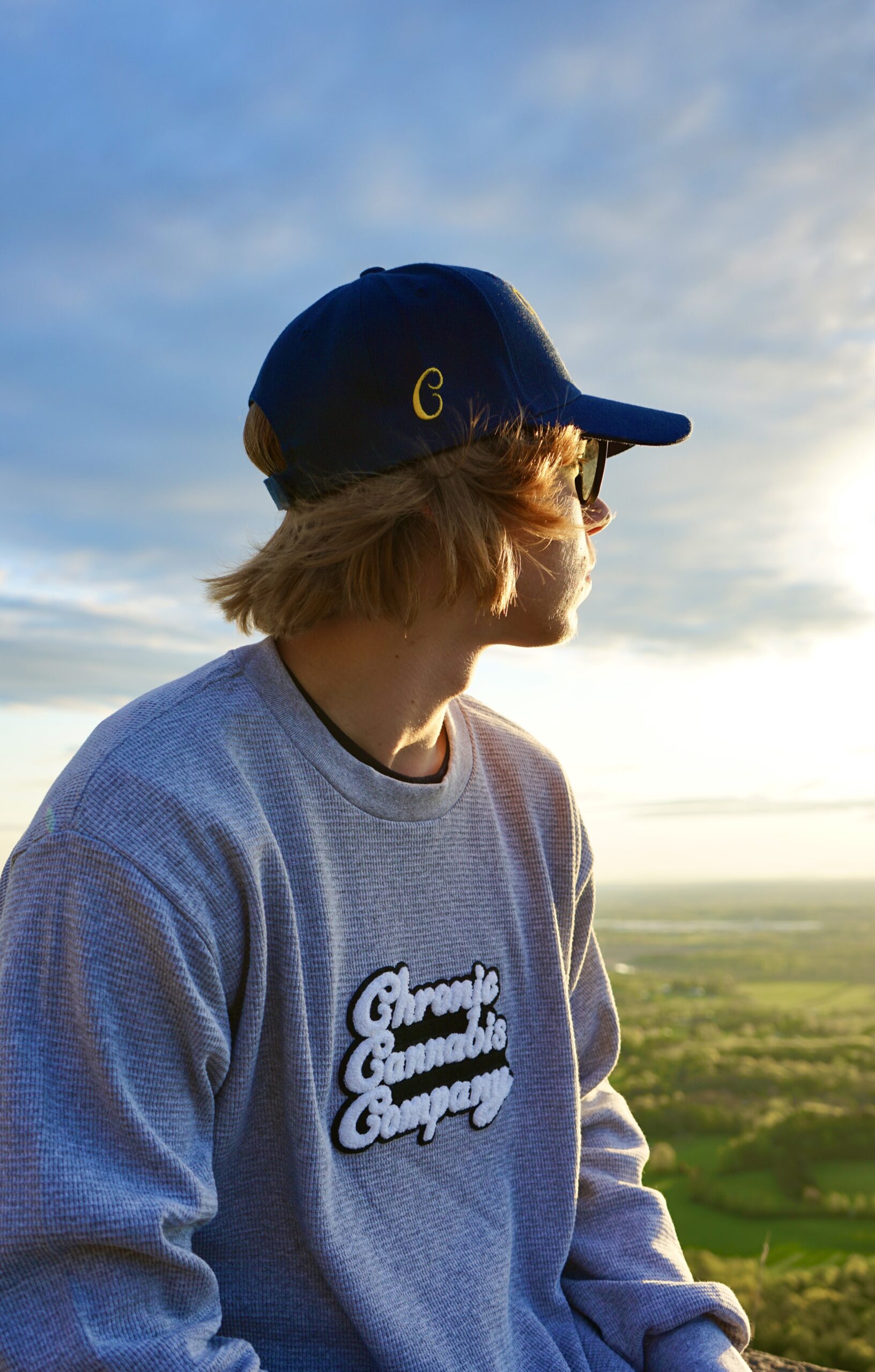 Person in cap enjoying sunset view outdoors.