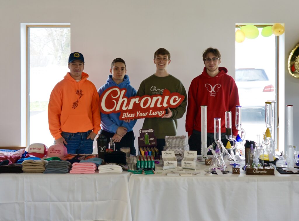 Four men displaying apparel and smoking accessories.