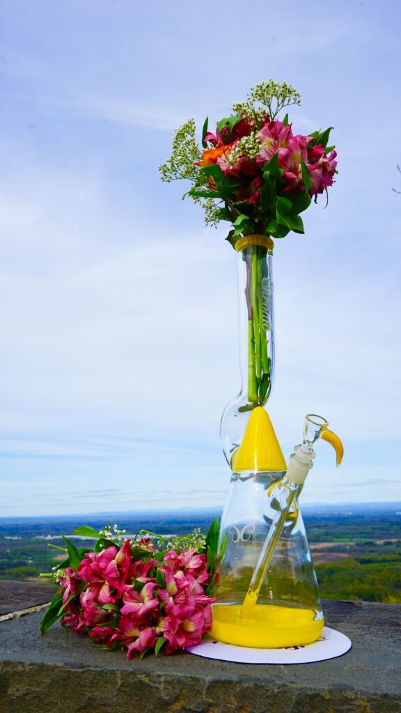 Colorful flowers in a glass container outdoors.